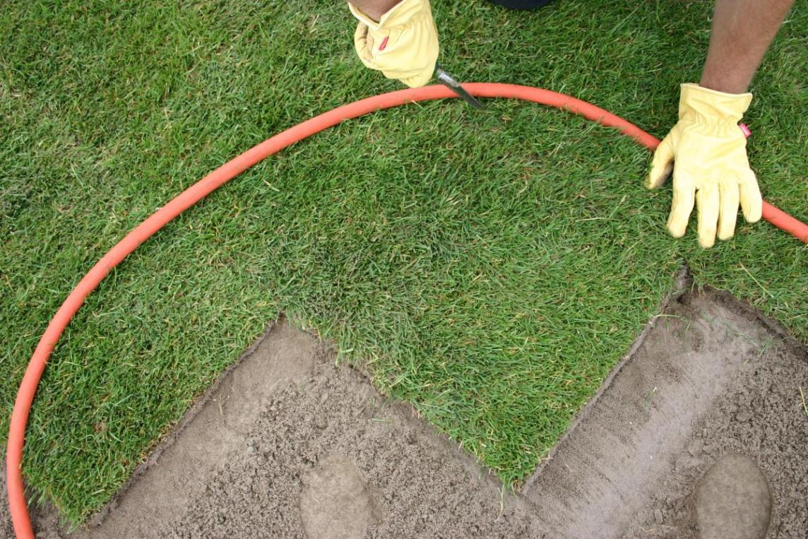 Rollrasen Rundungen mit einem Gartenschlauch formen und Konturen entlang schneiden